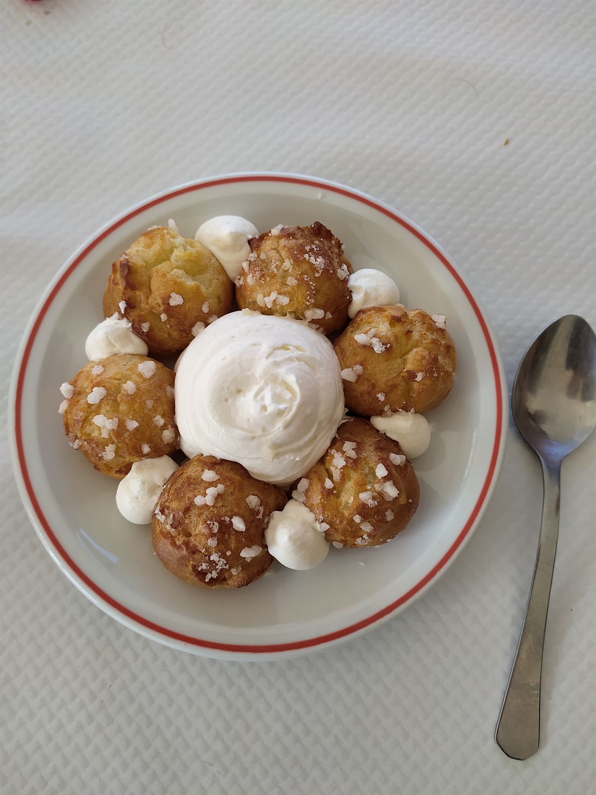 Chouquettes et chantilly sur assiette au liseré rouge